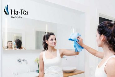 Housekeeper using Ha-Ra cloth to clean a window